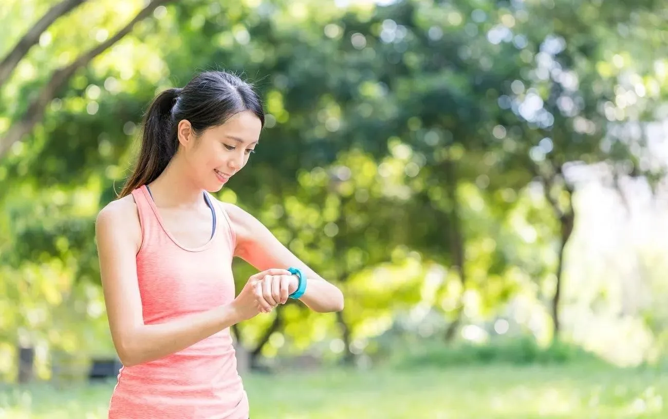 Человек смотрит на свой VO2 max в часах Apple и улыбается.