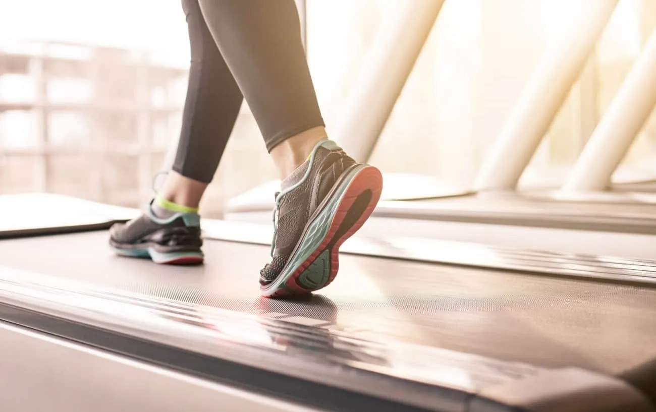 Крупный план человека's feet on a treadmill.