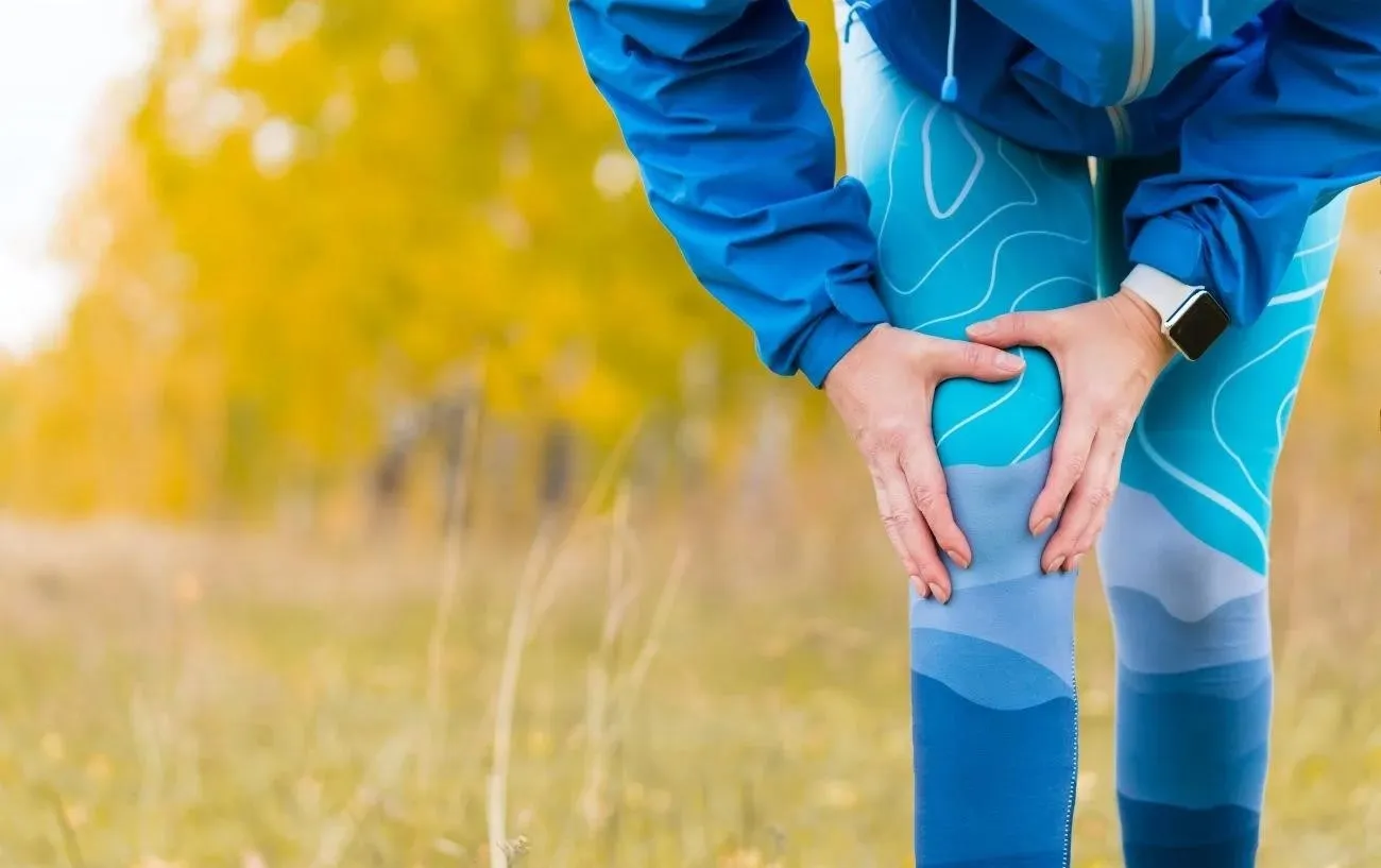 Человек с бегуном's knee, a running injury.