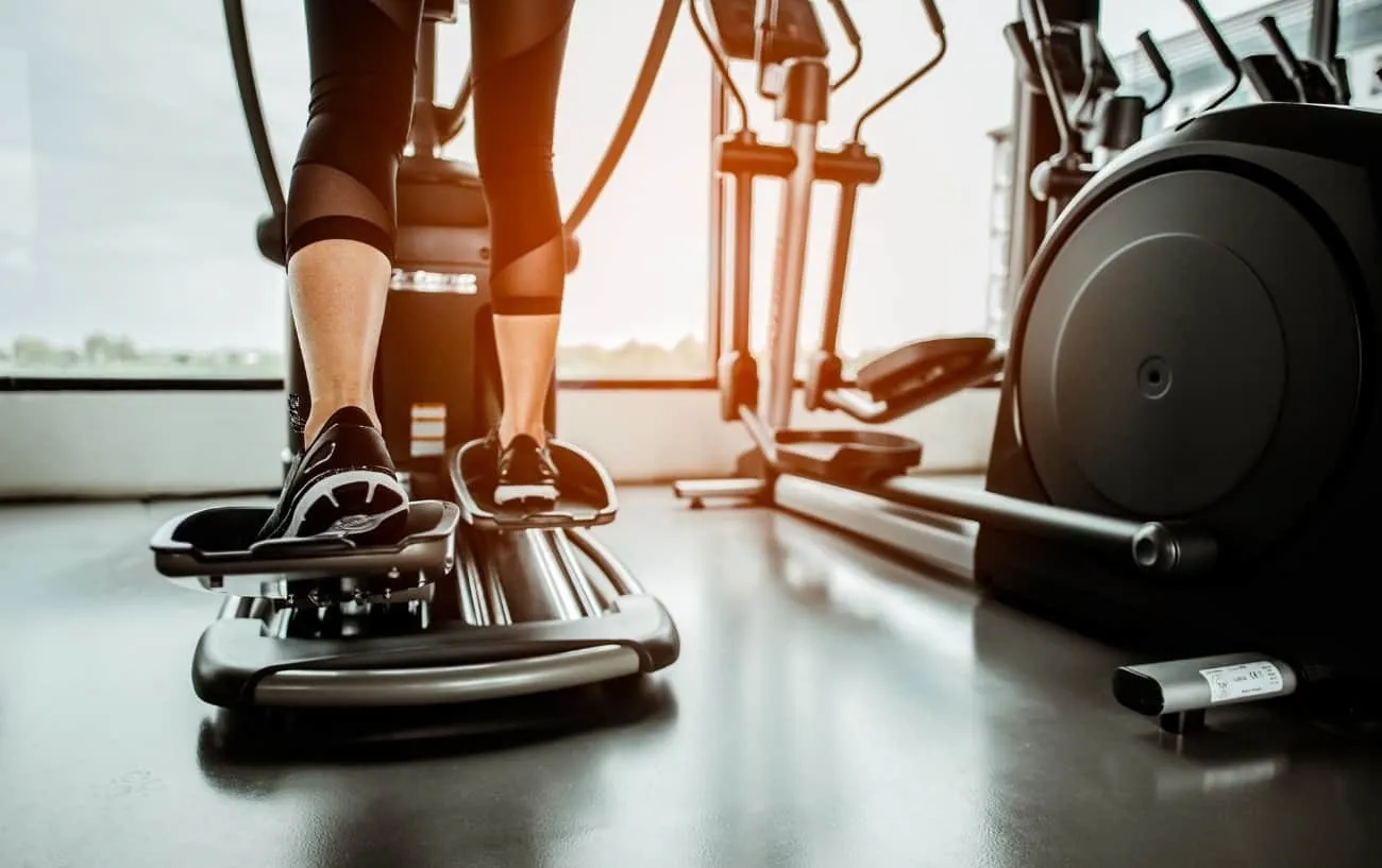 Крупный план человека's feet on an elliptical machine. 