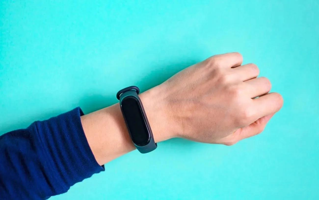 fitbit на запястье с синим фоном