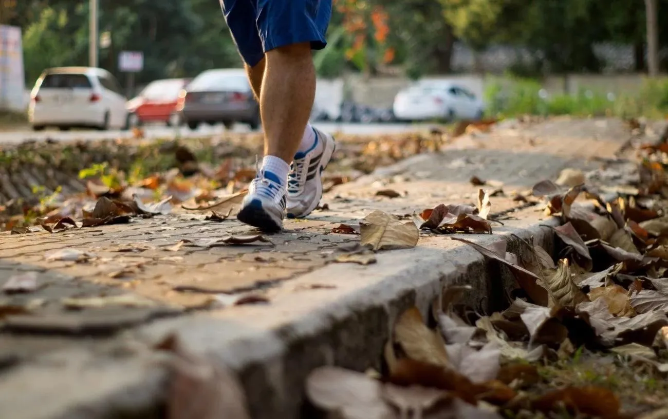 Крупный план бегуна's sneakers while running on a fall day.