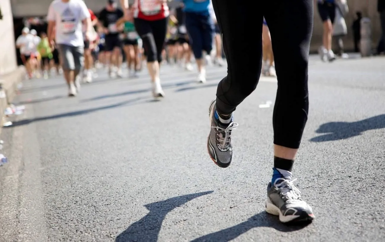 Крупный план бегунов' legs running a half marathon.