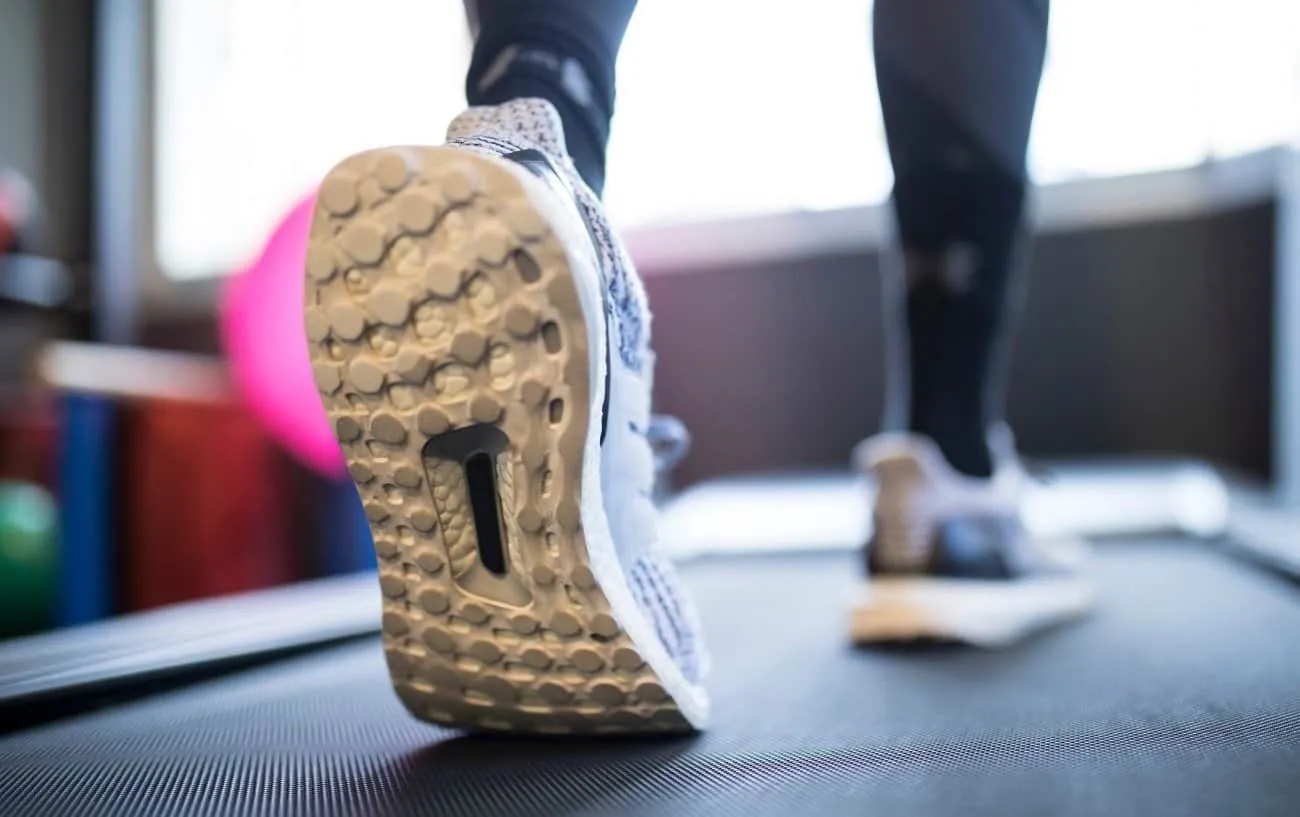 Женщина's feet on a treadmill.