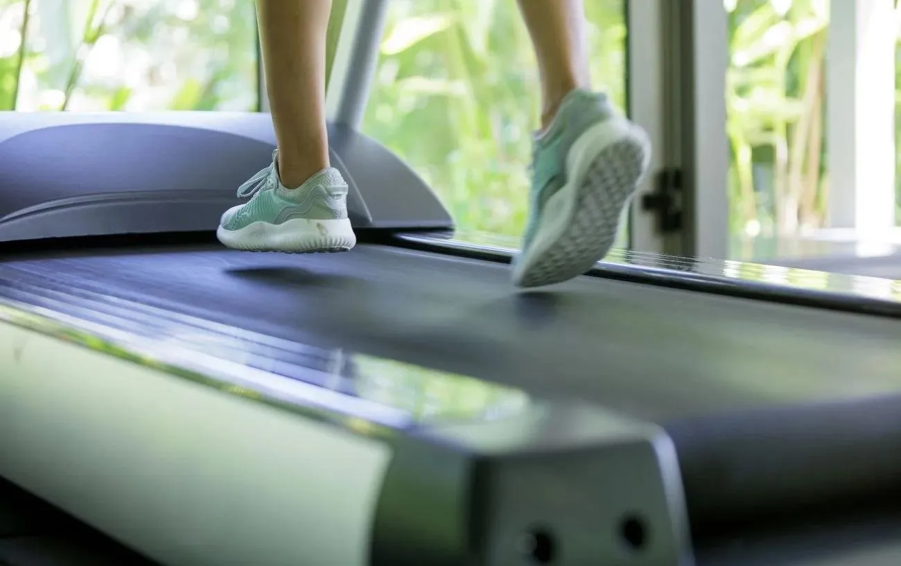 Крупный план человека's feet on a treadmill.