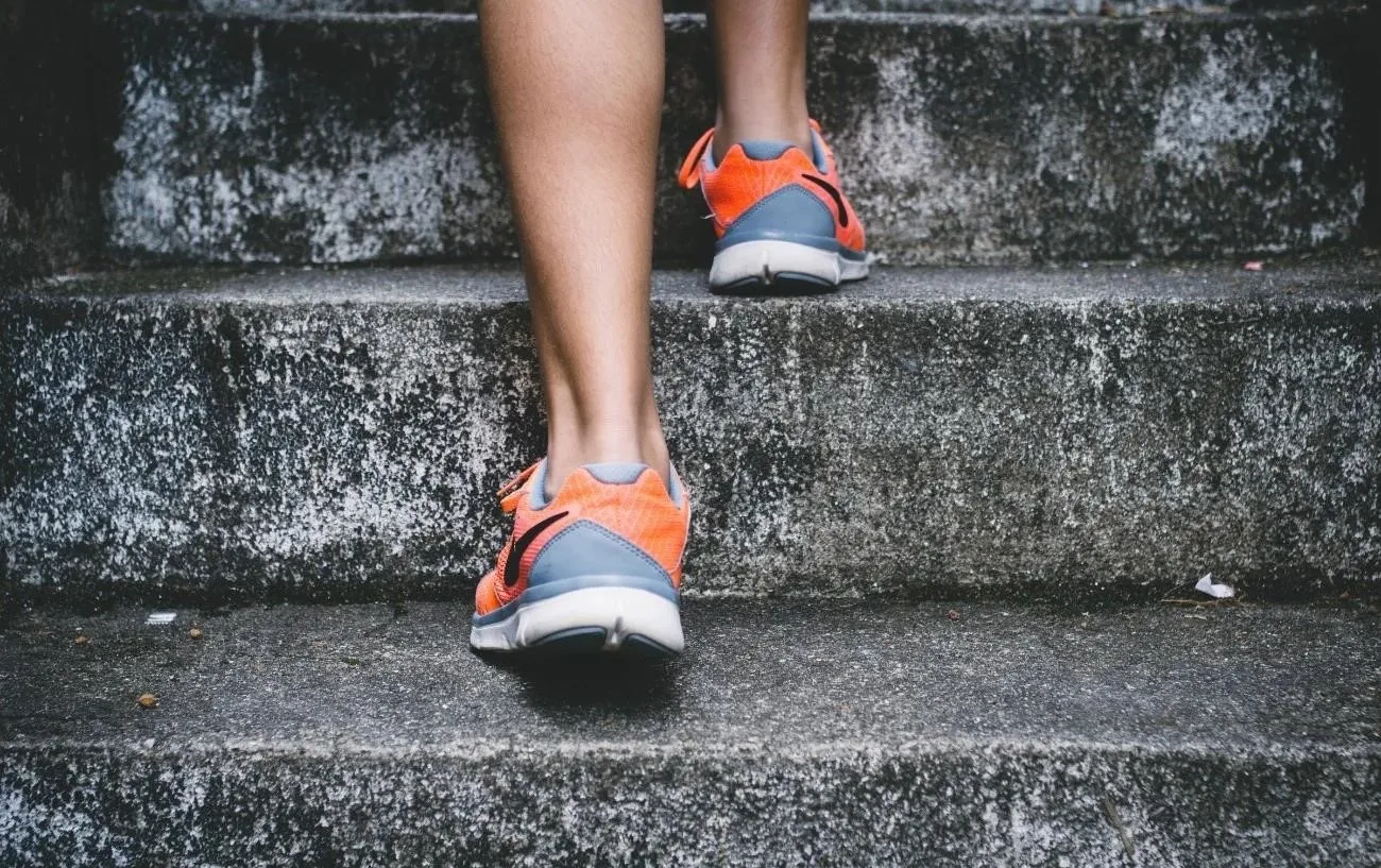 Крупный план человека's running shoes walking up stairs.