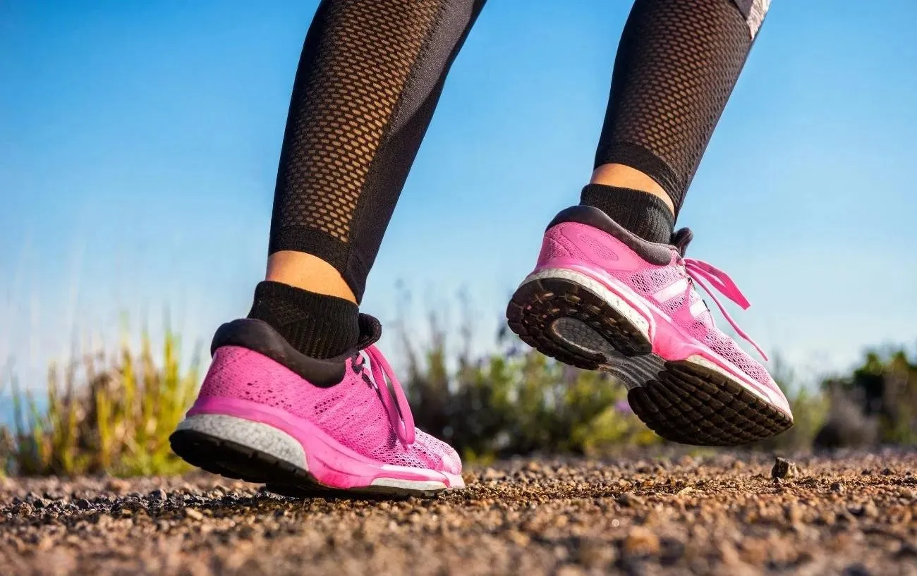 Крупный план человека's shoes while jogging.