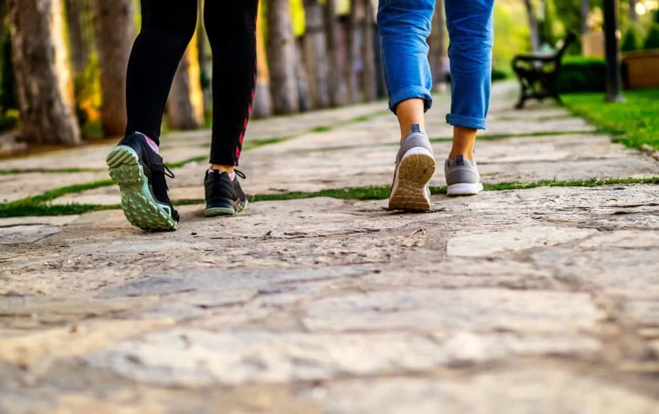 Крупный план двух людей's feet talking on a stone walkway. 