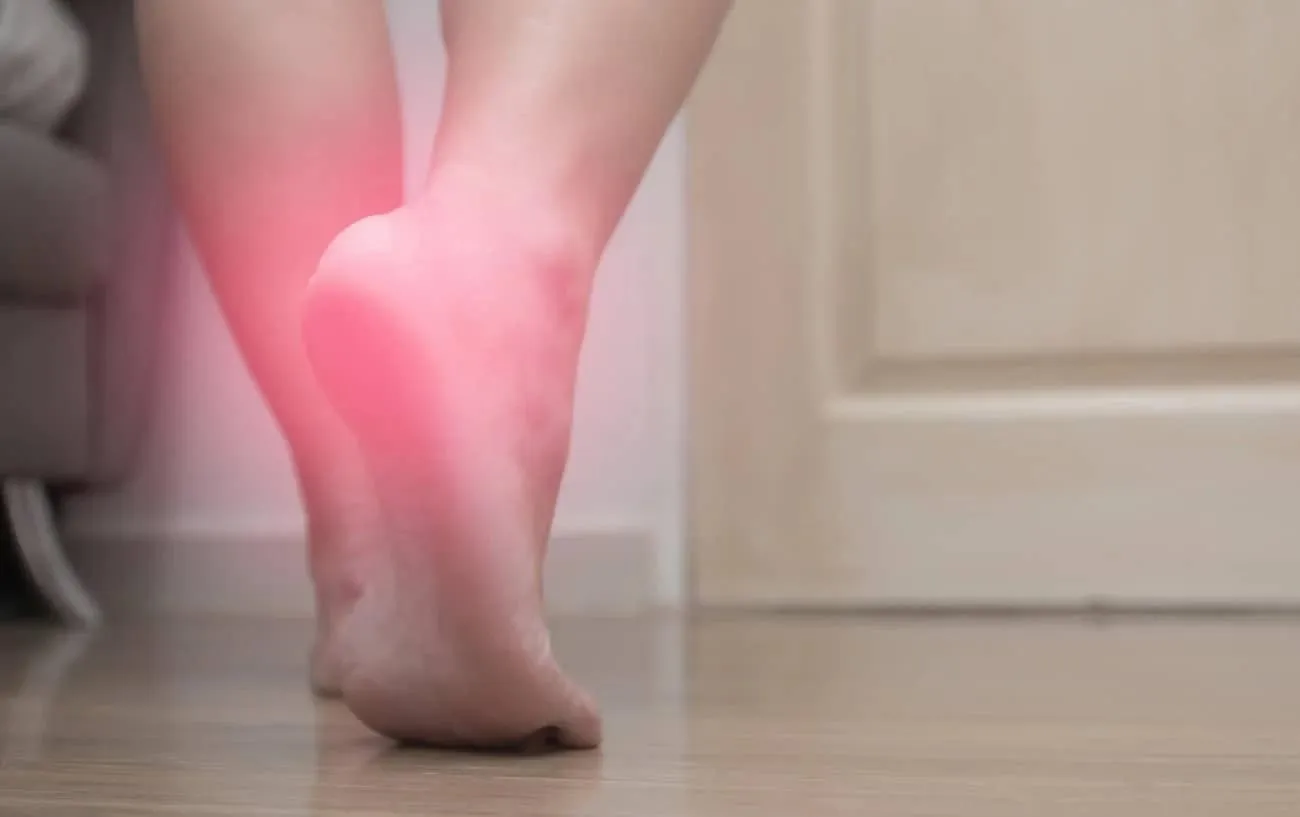 Крупный план человека's feet with a red glow on their heel showing pain.