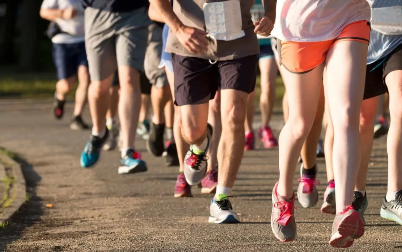 Бегуны крупным планом' legs running a 5k race. 