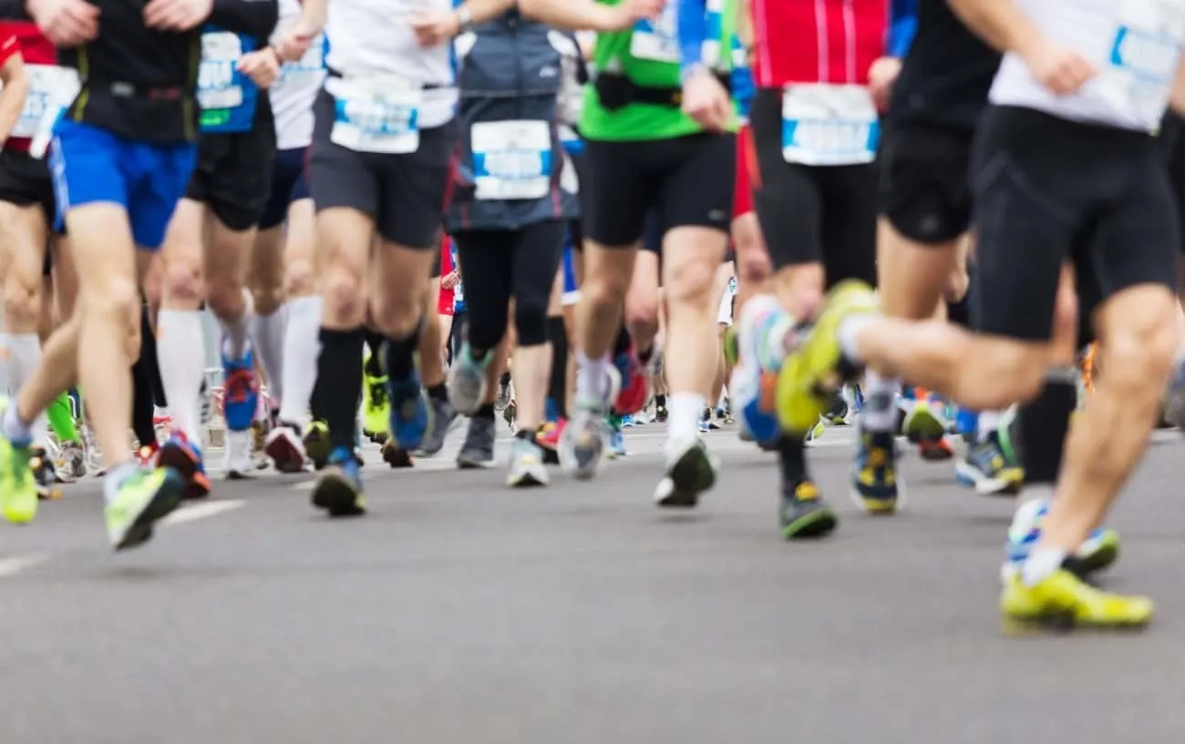 Крупный план бегунов' legs running a 5k race. 